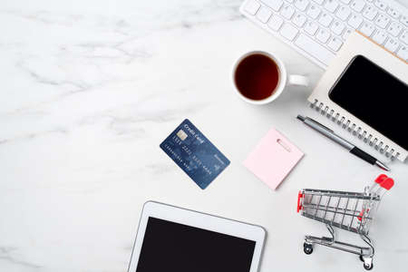 Top view of online shopping concept with credit card and electronics isolated on office marble white table background.の写真素材
