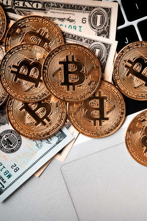 Business top view design concept of cryptocurrency bitcoin with USD Dollar paper currency money on laptop over dark black table background.の写真素材