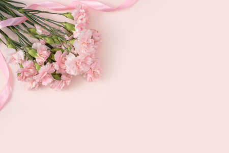 Design concept of Mother's day holiday greeting design with carnation bouquet on pastel pink table backgroundの写真素材