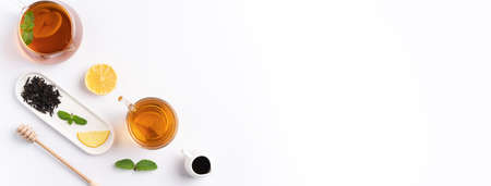 Design concept top view of honey black tea with yellow lemon and mint leaf on white table background.の写真素材