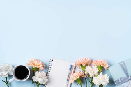 Design concpet of Mother's Day greeting with carnation flower, holiday gift idea and notebook diary on mother's desk background.の写真素材