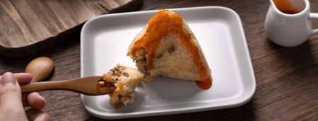 Eating Zongzi rice dumpling for Chinese traditional Dragon Boat Festival (Duanwu Festival) celebration event concept.の写真素材