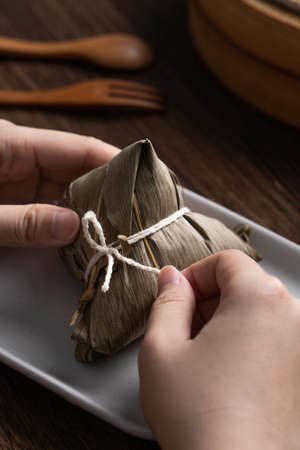 Eating Zongzi rice dumpling for Chinese traditional Dragon Boat Festival (Duanwu Festival)...