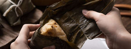 Eating Zongzi rice dumpling for Chinese traditional Dragon Boat Festival (Duanwu Festival) celebration event concept.の写真素材