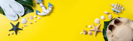 Summer beach design concept. Top view of holiday travel with shells, hat, slipper on yellow...