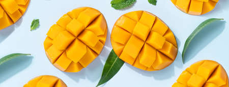 Mango design concept. Top view of diced fresh mango fruit pattern on blue table background.の写真素材