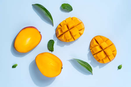Mango design concept. Top view of diced fresh mango fruit pattern on blue table background.の写真素材