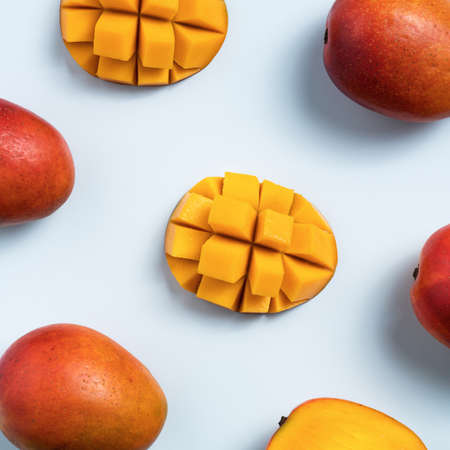 Mango design concept. Top view of diced fresh mango fruit pattern on blue table background.の写真素材