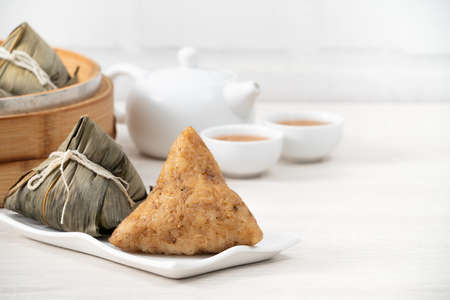 Zongzi. Rice dumpling for Chinese traditional Dragon Boat Festival (Duanwu Festival) on bright wooden table background.の素材 [FY310168806982]