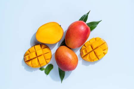 Mango design concept. Top view of diced fresh mango fruit pattern on blue table background.の写真素材