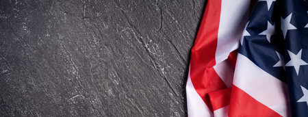Concept of US Independence day or Memorial day. National flag over dark slate table background.