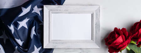 Concept of US Independence day or Memorial day. National flag and red rose over bright marble table background with picture frame.の写真素材