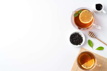 Design concept top view of honey black tea with yellow lemon and mint leaf on white table background.の写真素材
