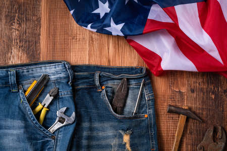 Top view design concept of Labor Day with working tools and jeans on wooden table background.の写真素材