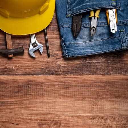 Top view design concept of Labor Day with working tools and jeans on wooden table background.の写真素材