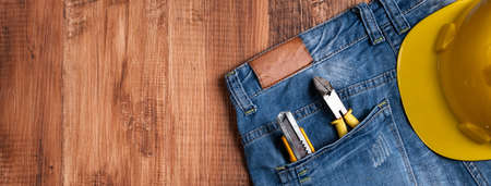 Top view design concept of Labor Day with working tools and jeans on wooden table background.の写真素材