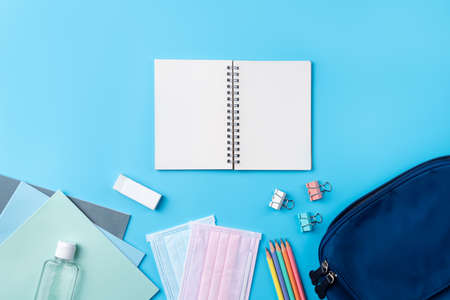 Top view of blue backpack with school stationery over blue table background, back to school design concept.の写真素材