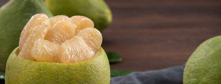 Close up of fresh peeled pomelo on wooden table background for Mid-Autumn Festival fruit.