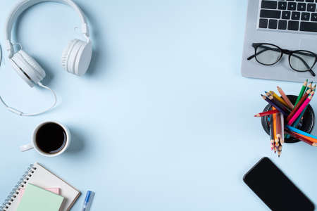 Online learning design concept. Top view of student table with computer, headphone and stationeries on blue table background.の写真素材