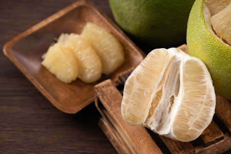Close up of fresh peeled pomelo on wooden table background for Mid-Autumn Festival fruit.の写真素材