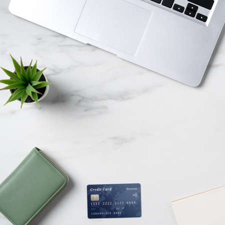Top view of online shopping concept with credit card and laptop computer isolated on office marble...