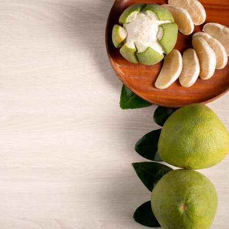 Top view of fresh pomelo on bright wooden table background for Mid-Autumn Festival fruit.の写真素材