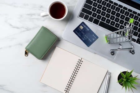Top view of online shopping concept with credit card and laptop computer isolated on office marble white table background.の写真素材