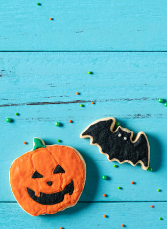 Top view of Halloween festive decorated baked icing gingerbread sugar cookies on blue background with copy space and flat lay.の写真素材