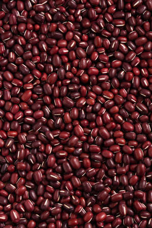 Top view of raw adzuki red bean as background with spoon.