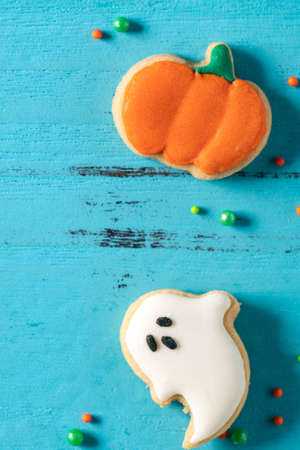 Top view of Halloween festive decorated baked icing gingerbread sugar cookies on blue background with copy space and flat lay.の写真素材