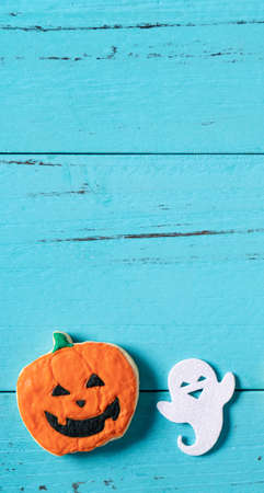 Top view of Halloween festive decorated baked icing gingerbread sugar cookies on blue background with copy space and flat lay.の写真素材