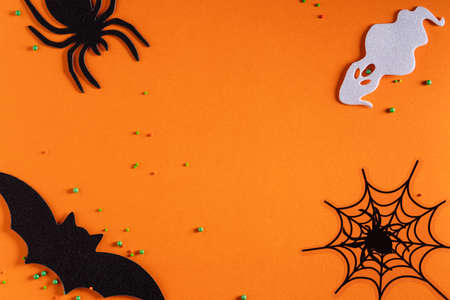 Top view of creative Halloween concept decoration on orange paper table background.