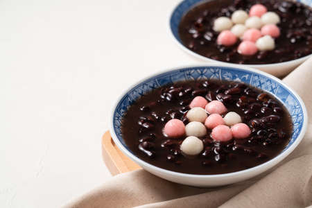 Close up of red and white tangyuan (tang yuan, glutinous rice dumpling balls) with sweet red bean...