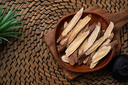 Top view of Chinese traditional herbal medicine Astragalus root on wooden table background.の素材 [FY310176391836]