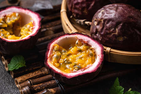 Close up of delicious juicy fresh passion fruit on gray table background.