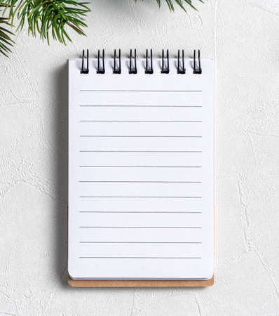 Top view of Christmas decorations background with blank notebook on white table background with copy...