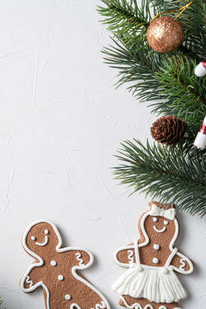 Top view of decorated Christmas gingerbread cookies with decorations on white table background with...