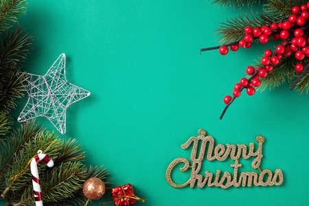 Top view of Christmas background design concept with fir tree branch and decorations on green table background.の写真素材