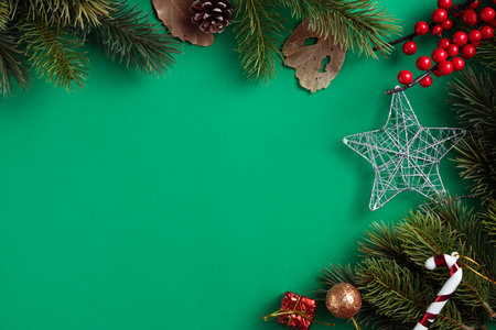 Top view of Christmas background design concept with fir tree branch and decorations on green table background.の写真素材