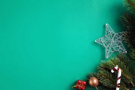 Top view of Christmas background design concept with fir tree branch and decorations on green table background.の写真素材