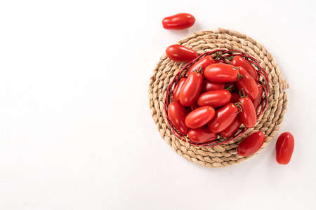 Top view of fresh cherry tomatoes over white table backgroundの写真素材