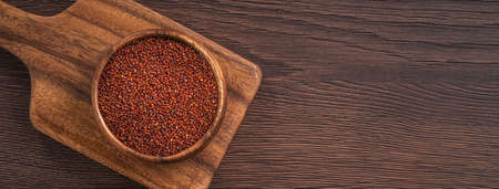 Top view of organic red in a bowl on wooden table background.