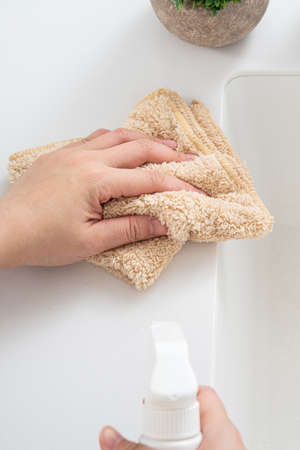 Woman housewife is doing the spring cleaning at home kitchen with using rag, spraying bottle cleaner to wipe the counter table surface.の写真素材