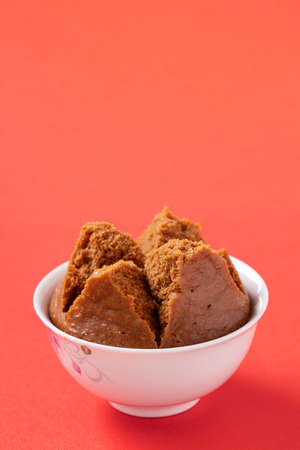 Close up of delicious Chinese steamed sponge cake named Fa Gao for lunar new year festival traditional food over red table background.の写真素材