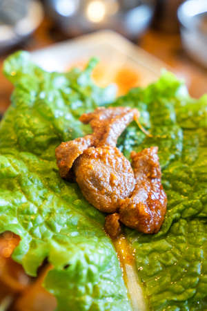 Close up of ssam Korean BBQ, pan-fried black pork with lettuce meal in Korea restaurant, fresh delicious korean cuisine.の写真素材