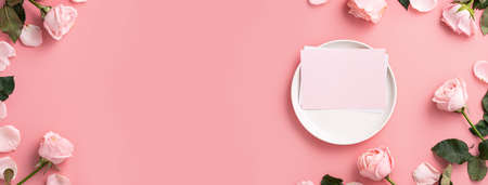 Top view of Mother's Day sending gift and meal design concept background with pink rose flower on pink table backgroundの写真素材