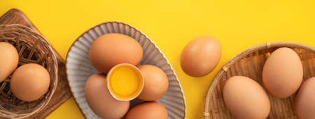 Top view of fresh brown chicken eggs isolated on yellow table background