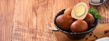 Close up of delicious traditional Taiwanese famous food tea eggs with in a bowl on wooden table background.の写真素材