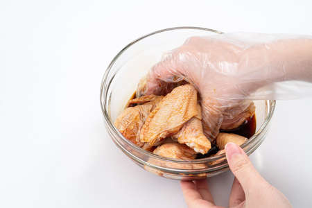 Cooking teriyaki sweet sauced chicken wings at home kitchen, recipe for Japanese style roasted food.の写真素材