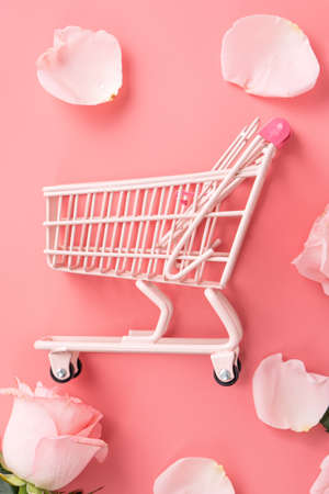 Mother's Day shopping design concept background with pink rose flower and cart on pink table backgroundの写真素材